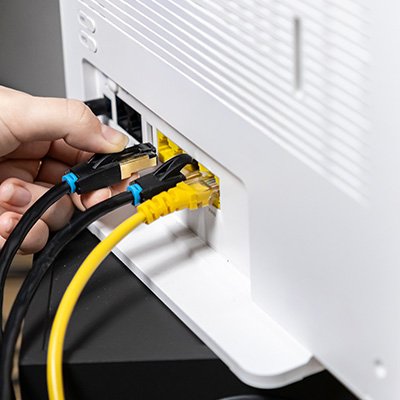 Connecting copper and fibre cables to a network device for installation.